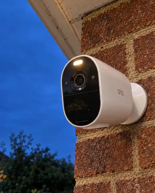 A security camera under the eaves of a brick house, from a Verisure film